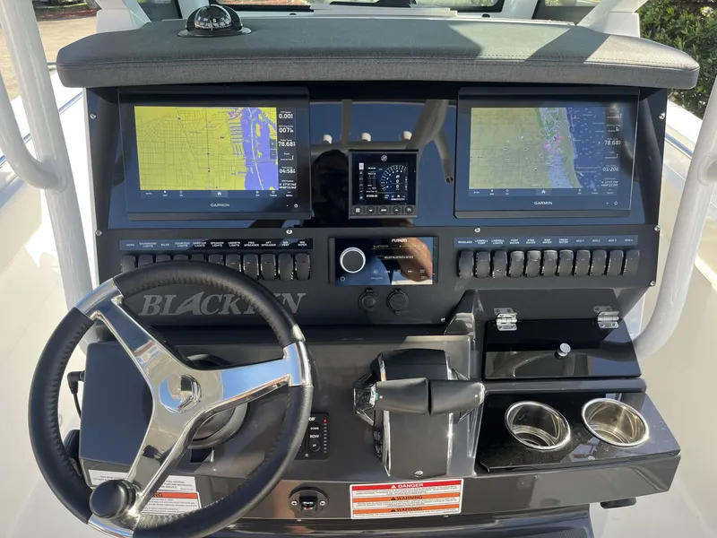 Slide: The Image of 2023 Blackfin 272 boat dashboard with dual Garmin displays and steering wheel. - 15