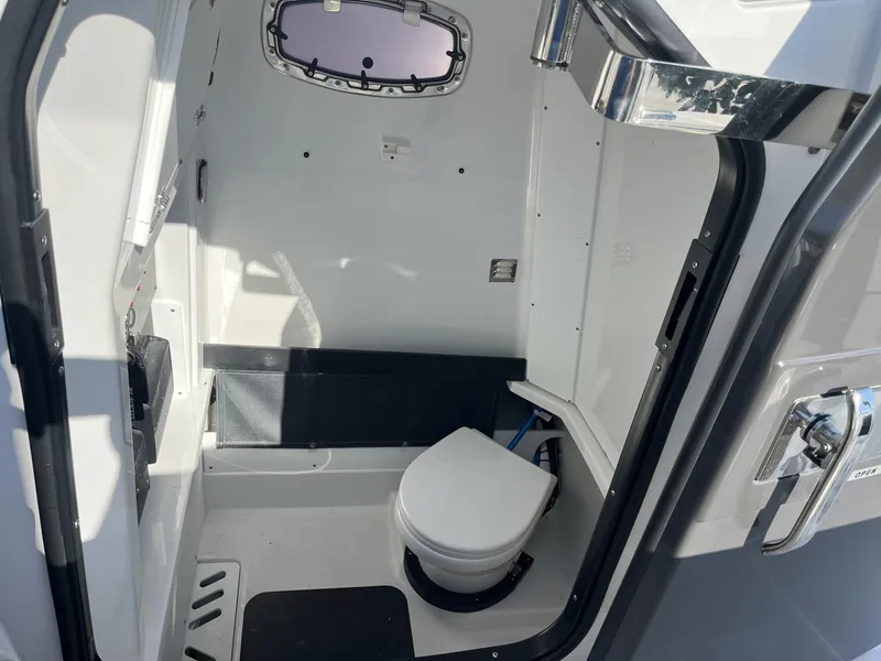 Slide: The Image of 2023 Blackfin 272 boat interior with compact marine toilet and window. - 24