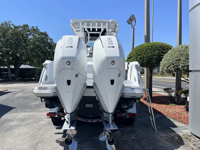 Slide: The Image of 2023 Blackfin 272 boat with dual outboard engines, parked outdoors on a sunny day. - 5