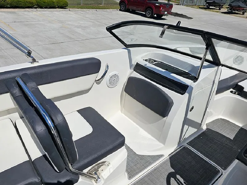 Slide: The Image of 2021 Bayliner VR5 Bowrider OB interior with seating and dashboard, parked on concrete. - 17