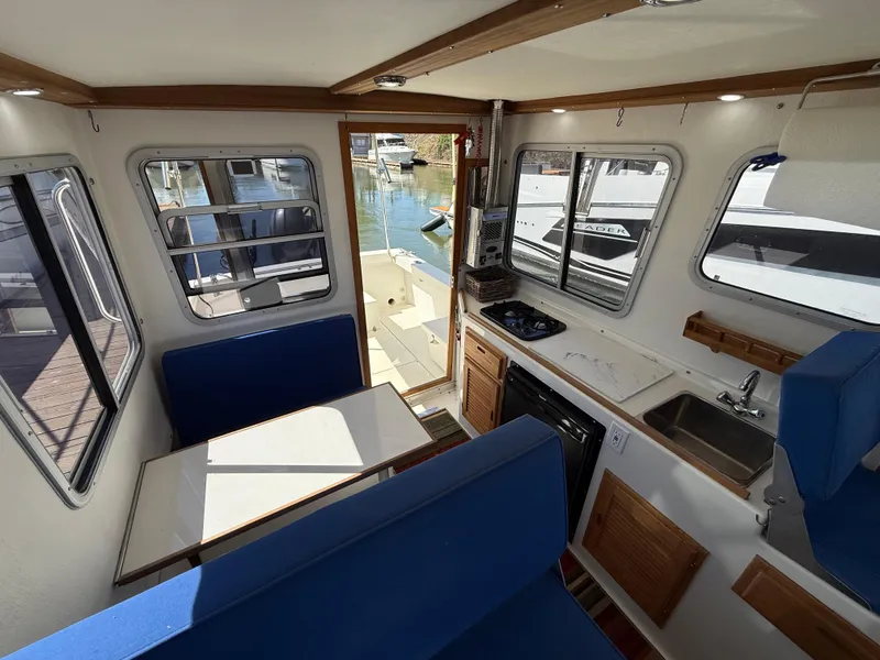 Slide: The Image of 2018 Rosborough 246 Yarmouth boat interior with dining area, kitchenette, and marina view. - 10