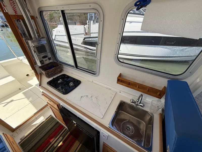Slide: The Image of 2018 Rosborough 246 Yarmouth boat interior with kitchen, stove, sink, and window view. - 11