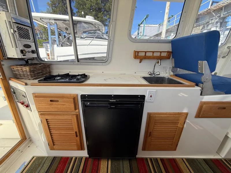Slide: The Image of Compact kitchen area in 2018 Rosborough 246 Yarmouth boat with stove, sink, and fridge. - 12