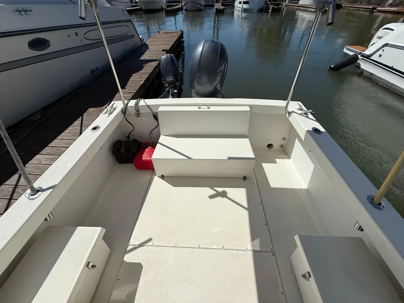 Slide: The Image of 2018 Rosborough 246 Yarmouth boat interior at dock, featuring seating and outboard motor. - 6