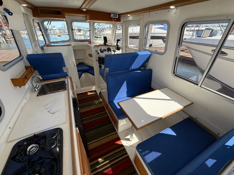 Slide: The Image of Interior of 2018 Rosborough 246 Yarmouth boat with blue seating and kitchenette. - 9