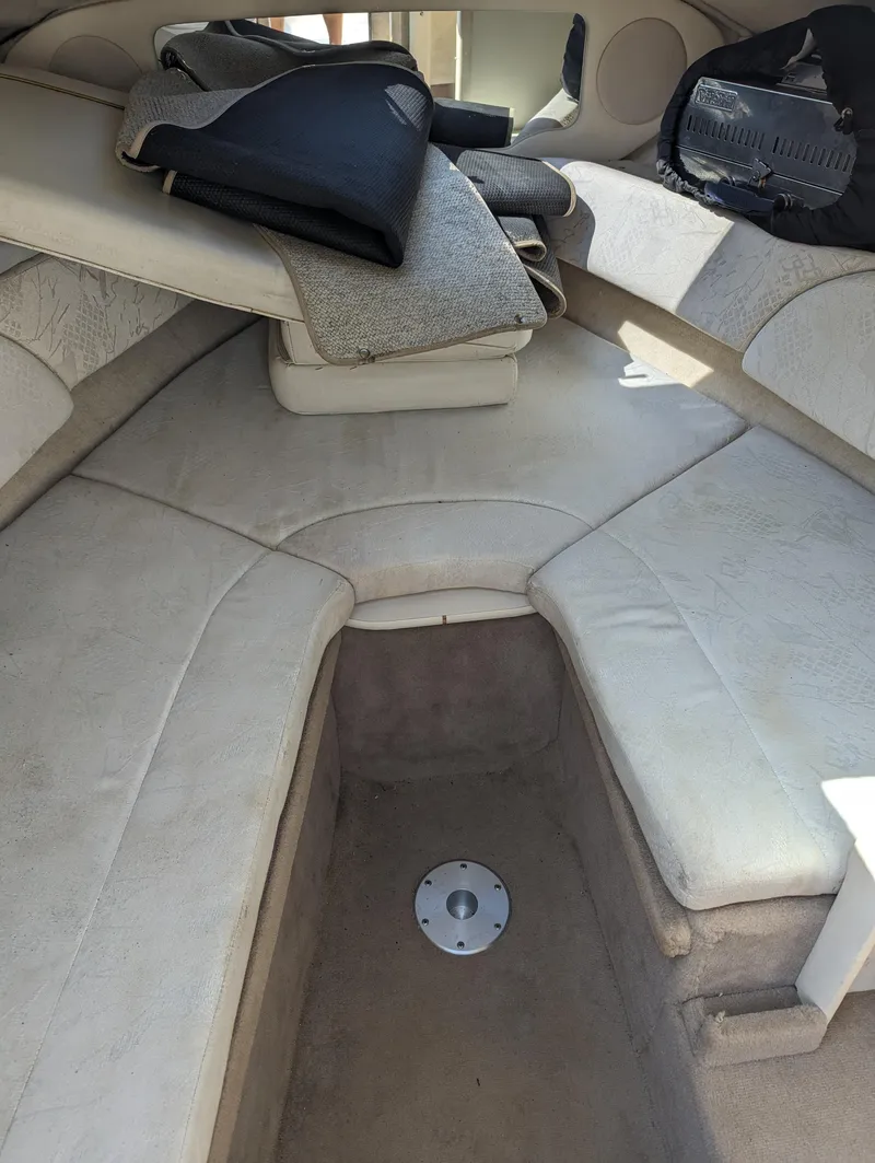Slide: The Image of 2001 Sea Ray 225 Weekender cabin interior with cushioned seating and storage. - 12