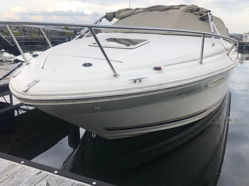 Slide: The Image of 2001 Sea Ray 225 Weekender boat docked, featuring sleek design and covered cabin. - 4