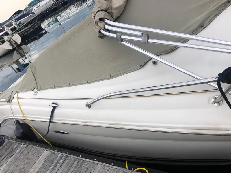 Slide: The Image of 2001 Sea Ray 225 Weekender boat docked with cover and railing visible. - 5