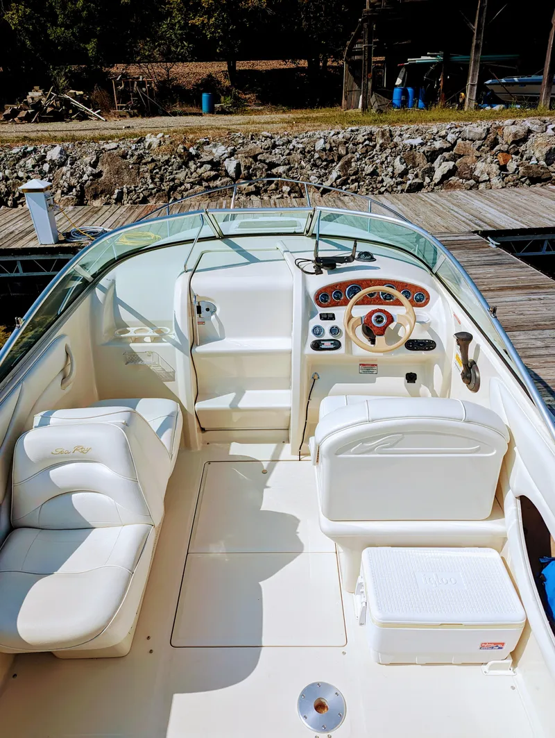 Slide: The Image of 2001 Sea Ray 225 Weekender boat interior with white seating and control panel. - 9