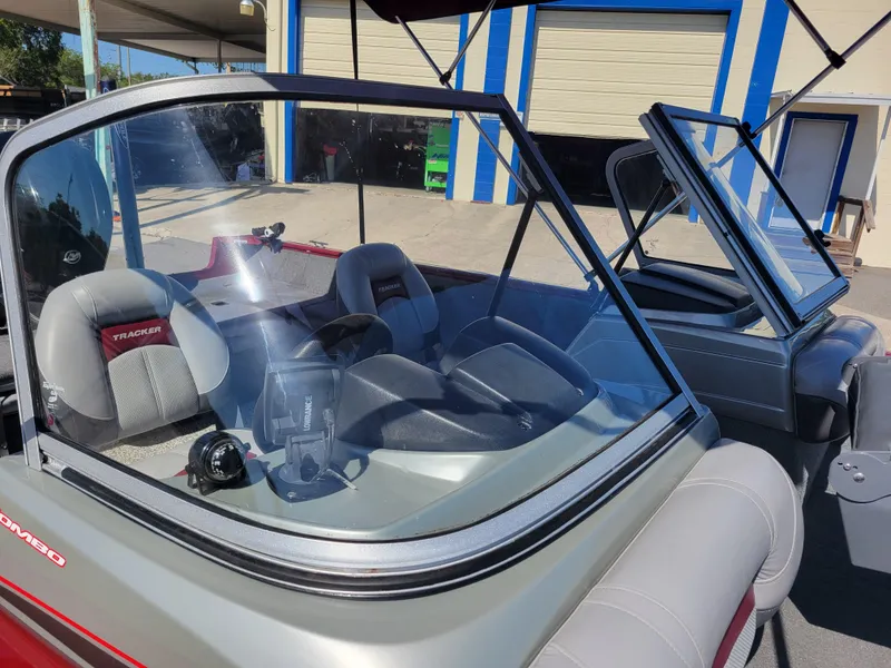 Slide: The Image of 2016 Tracker Pro Guide V-175 Combo boat with windshield and seating, parked outdoors. - 23