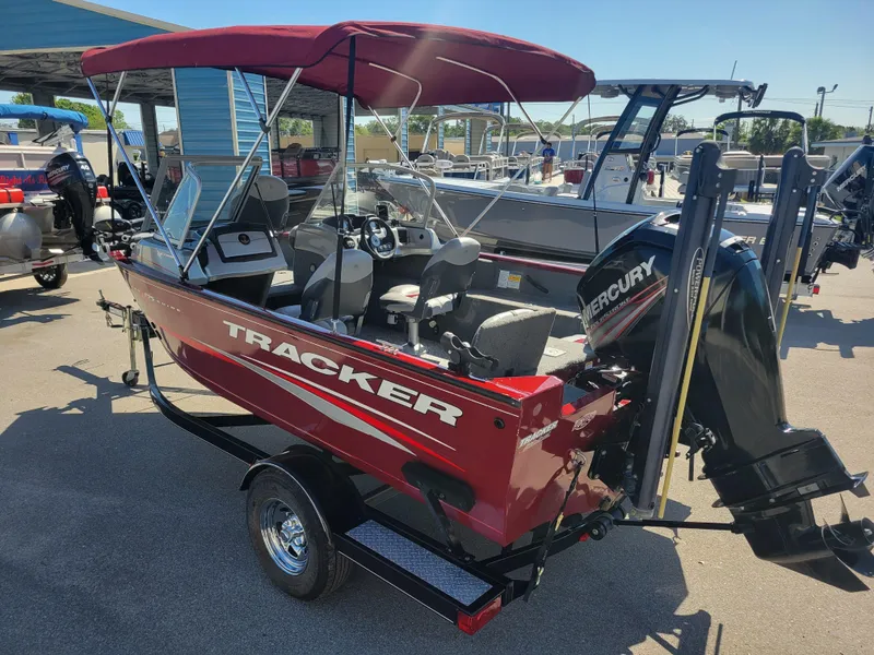 Slide: The Image of 2016 Tracker Pro Guide V-175 Combo boat with Mercury engine, red exterior, parked outdoors. - 7