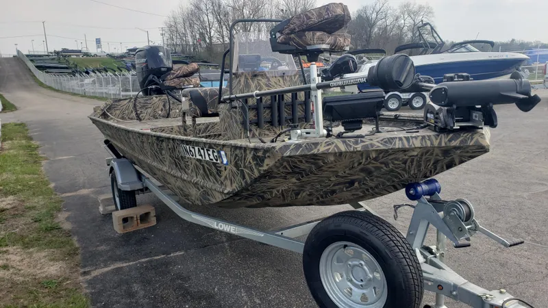 Slide: The Image of 2021 Lowe RTX1760PT camo fishing boat on trailer, equipped with motor and accessories. - 2