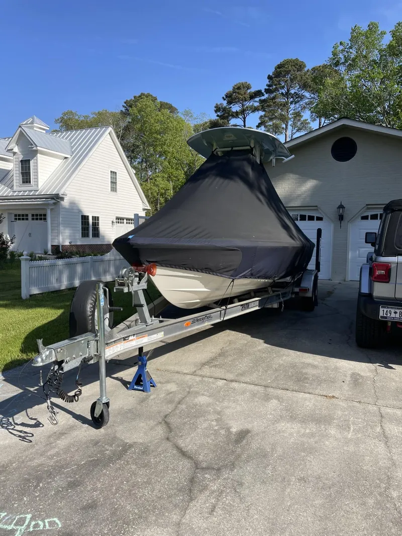 Slide: The Image of 2021 Pathfinder 2200 TRS boat on trailer, covered, parked in driveway. - 10