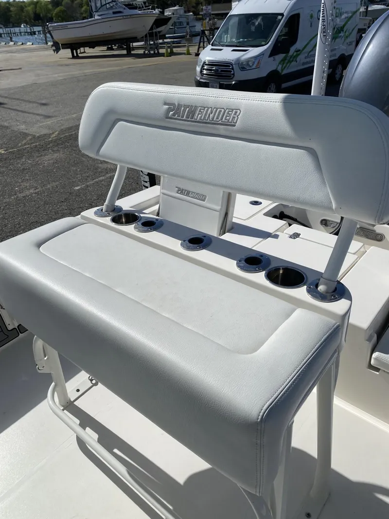 Slide: The Image of 2021 Pathfinder 2200 TRS boat seat with cup holders, docked near a marina. - 7