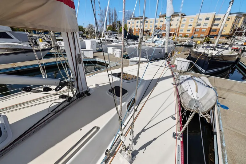 Slide: The Image of 1994 J Boats J/130 sailboat docked at a marina with nearby buildings. - 15