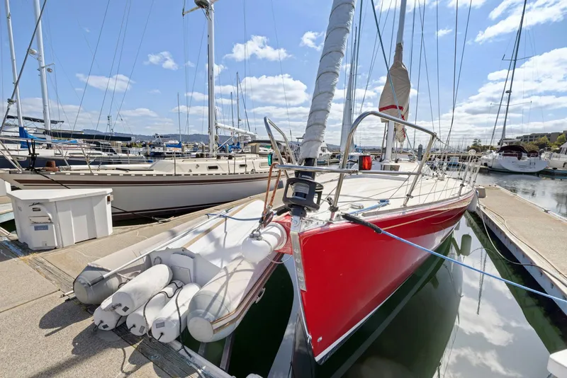 Slide: The Image of Red 1994 J Boats J/130 sailboat docked at marina under blue sky. - 2