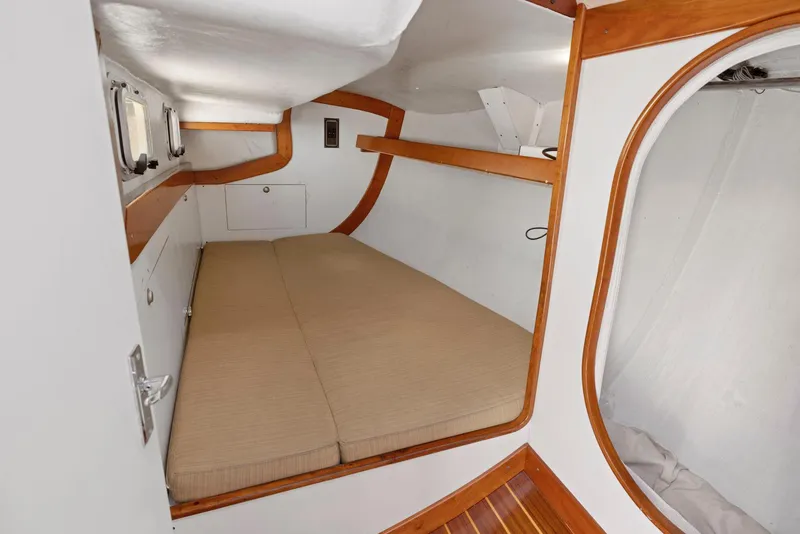 Slide: The Image of Interior cabin of 1994 J Boats J/130, featuring a cozy bed and wooden accents. - 25