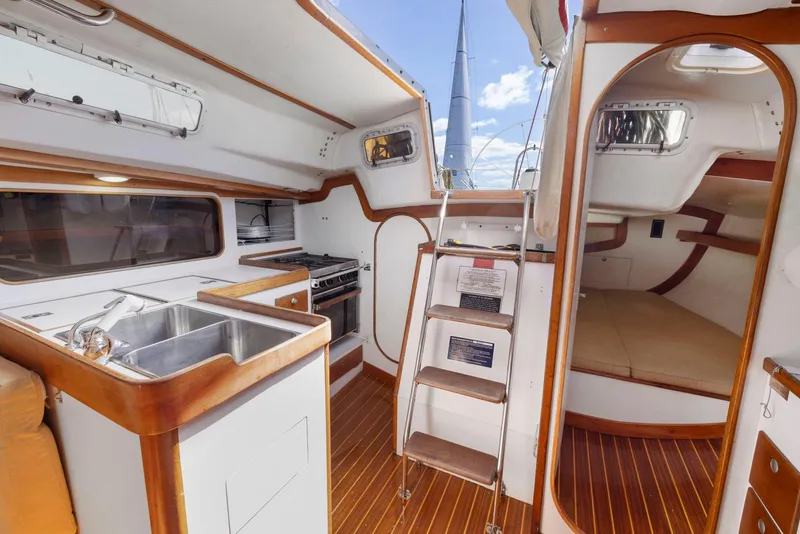 Slide: The Image of Interior of 1994 J Boats J/130 sailboat with kitchen, ladder, and cozy cabin space. - 26