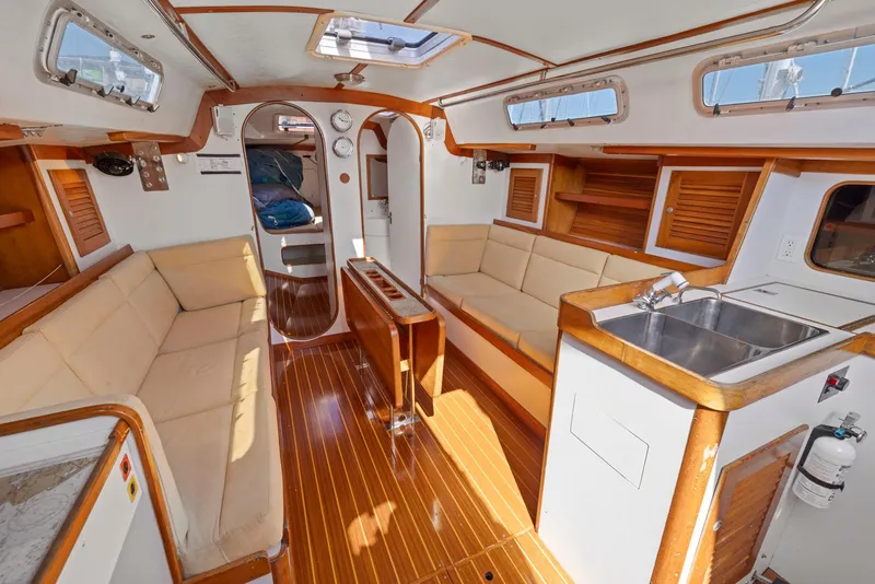 Slide: The Image of Interior of 1994 J Boats J/130 sailboat with wood accents and beige seating. - 27