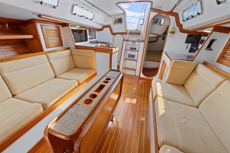 Slide: The Image of Luxurious interior of a 1994 J Boats J/130 sailboat with wooden finishes and beige seating. - 33