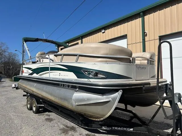 Slide: The Image of 2010 Sun Tracker PARTY BARGE 22 Regency Edition pontoon boat on trailer, parked outdoors. - 24