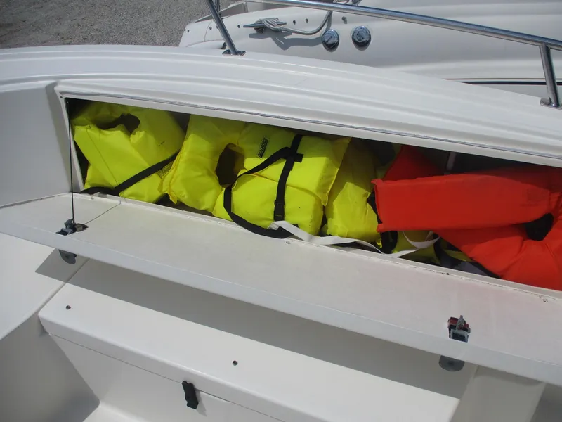 Slide: The Image of Storage compartment with life jackets on a 2006 Pursuit 2670 Center Console boat. - 11