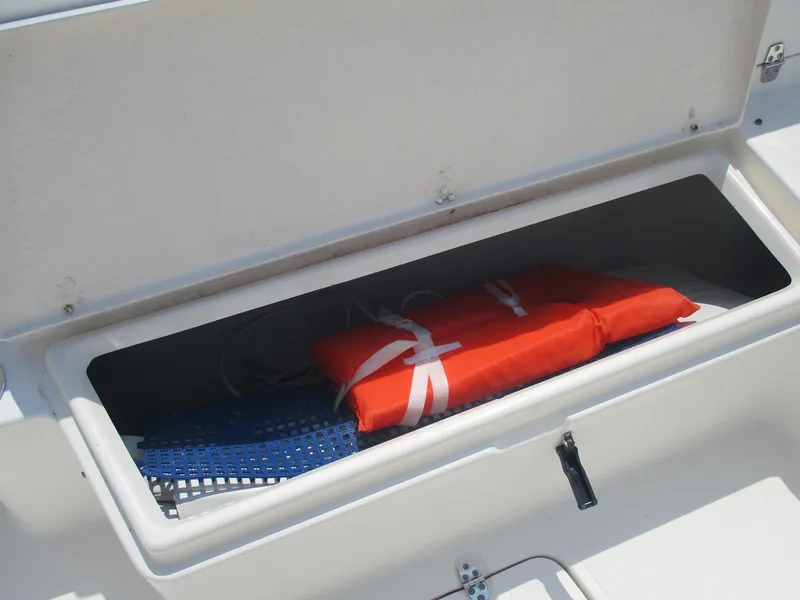 Slide: The Image of Storage compartment on a 2006 Pursuit 2670 Center Console with life jacket and gear. - 13