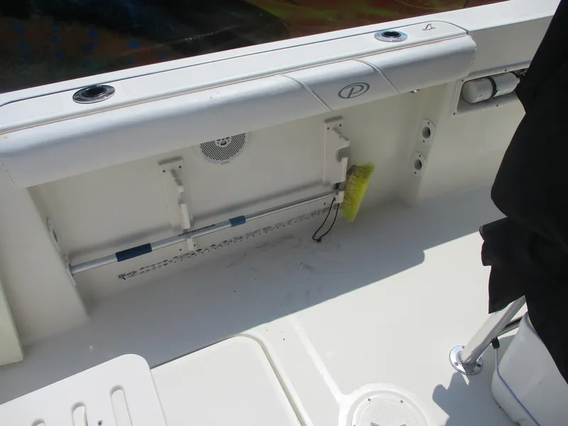 Slide: The Image of 2006 Pursuit 2670 Center Console boat interior with rod holders and storage compartment. - 17