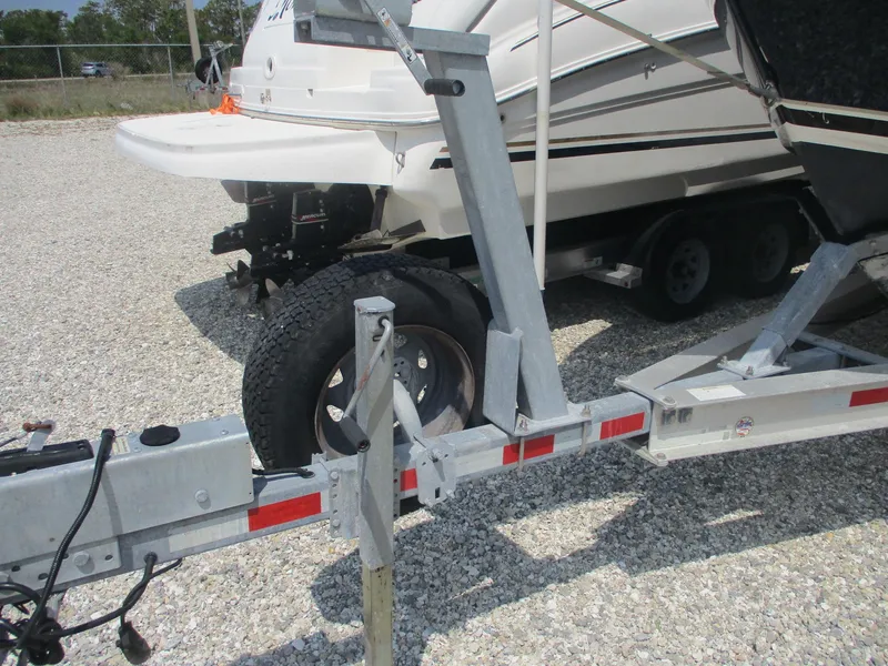 Slide: The Image of 2006 Pursuit 2670 Center Console boat on trailer, parked on gravel. - 19