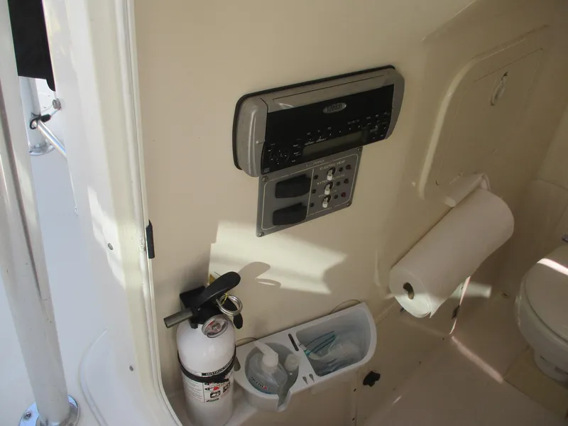 Slide: The Image of 2006 Pursuit 2670 Center Console interior with stereo, fire extinguisher, and toilet paper holder. - 22
