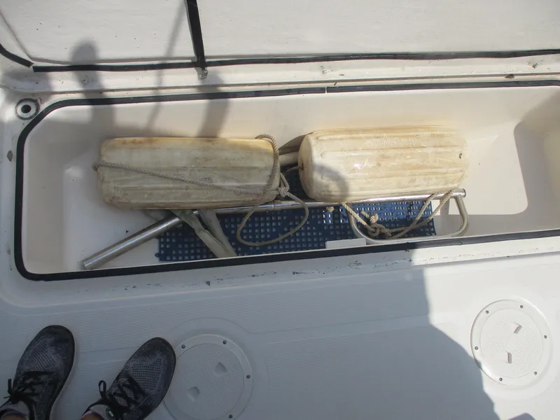 Slide: The Image of Storage compartment on a 2006 Pursuit 2670 Center Console boat with fenders and equipment. - 6