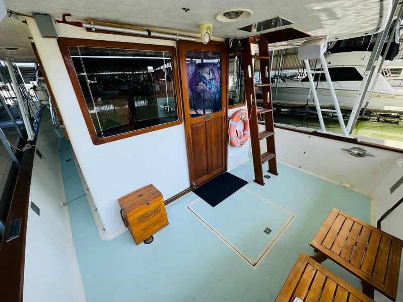 Slide: The Image of 1984 Fu Hwa Sea Horse 34 boat deck with wooden door, ladder, and seating area. - 12