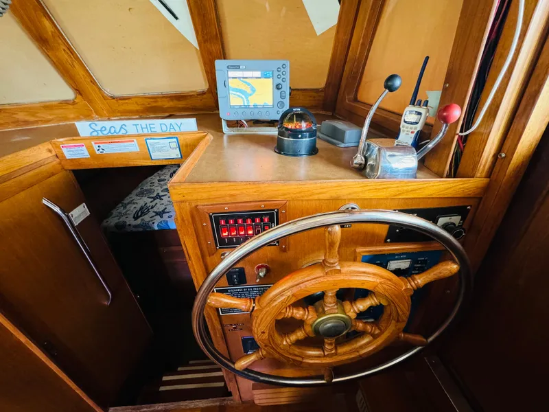 Slide: The Image of 1984 Fu Hwa Sea Horse 34 helm with wooden wheel, navigation instruments, and cozy cabin entrance. - 32