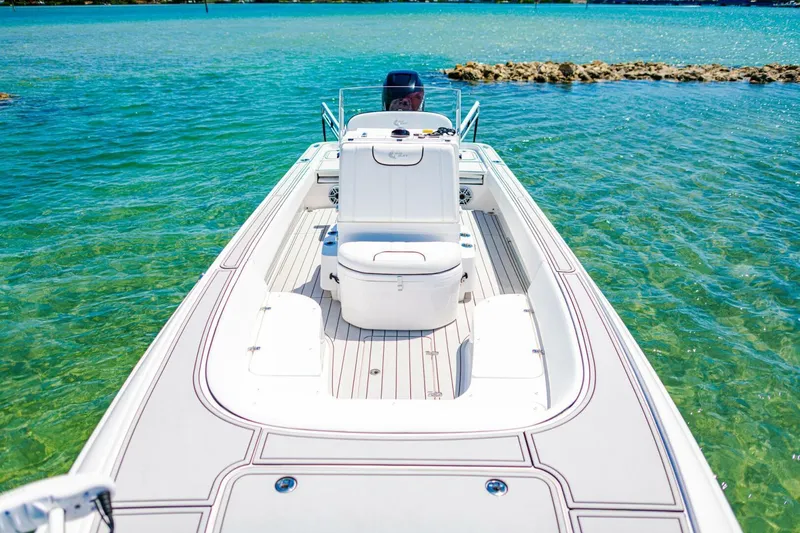 Slide: The Image of 2023 Contender 25 Bay boat on clear turquoise water, showcasing sleek design and spacious deck. - 13