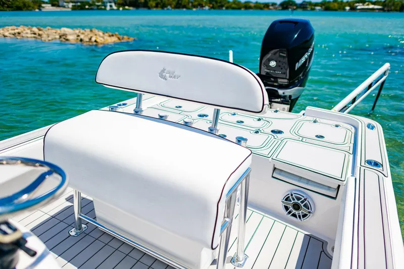 Slide: The Image of 2023 Contender 25 Bay boat interior with seating and motor, on clear blue water. - 18