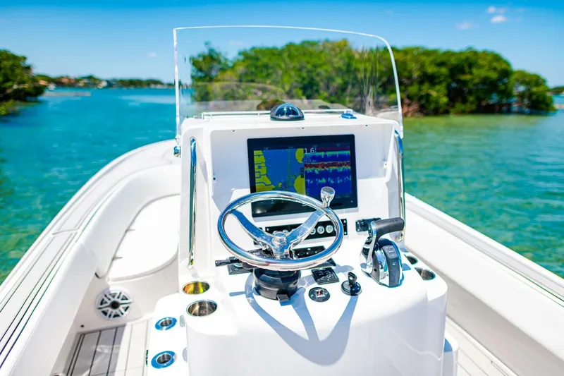 Slide: The Image of 2023 Contender 25 Bay boat dashboard with navigation system on clear water. - 19