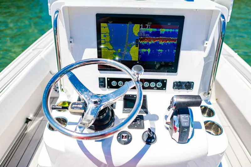 Slide: The Image of Steering console of 2023 Contender 25 Bay boat with navigation display and controls. - 21