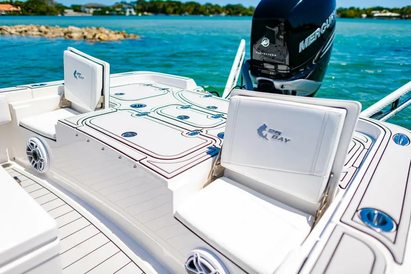 Slide: The Image of 2023 Contender 25 Bay boat with seating and Mercury engine on a sunny day. - 24