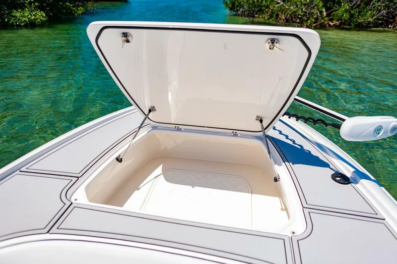 Slide: The Image of 2023 Contender 25 Bay boat with open storage compartment on clear water. - 9