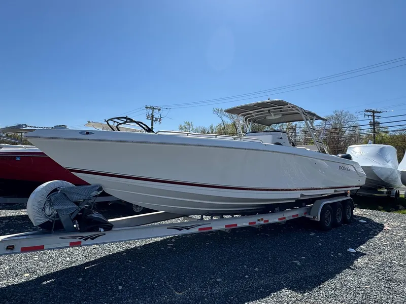 Slide: The Image of 2008 Donzi 35ZX boat on trailer, parked outdoors under clear blue sky. - 3