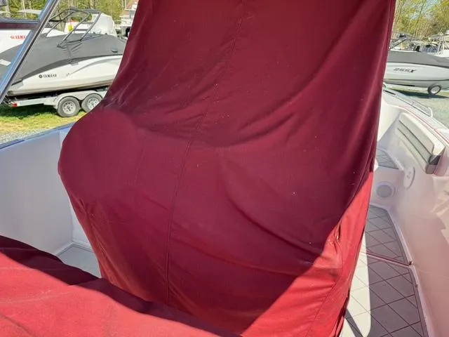 Slide: The Image of 2008 Donzi 35ZX boat with maroon cover, parked near other boats. - 9