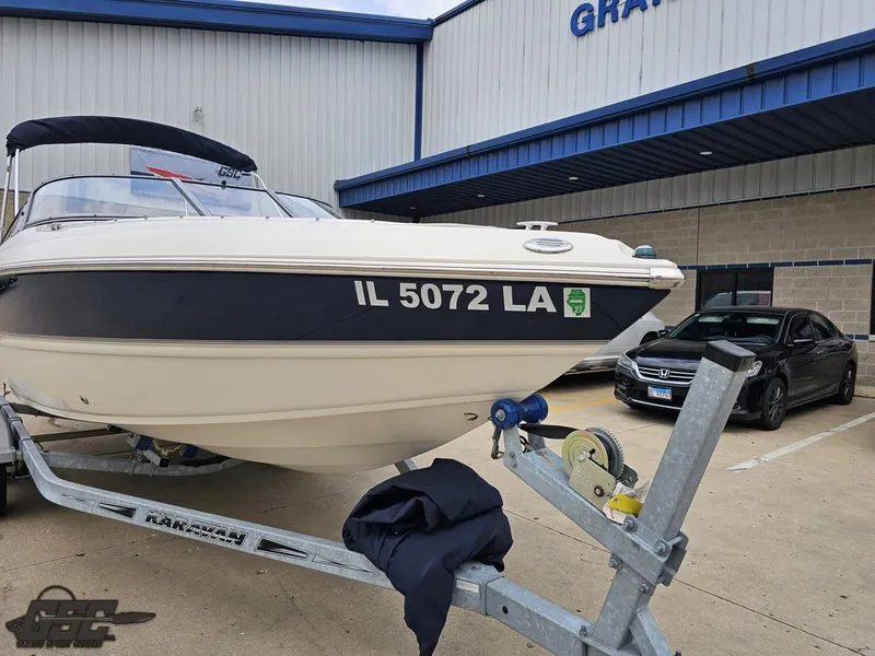 Slide: The Image of 2013 Stingray 225 LR boat on trailer, parked outside a building. - 13