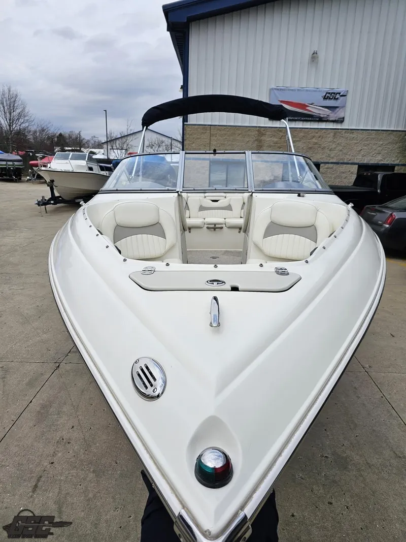 Slide: The Image of 2013 Stingray 225 LR boat with white exterior, docked outdoors. - 15