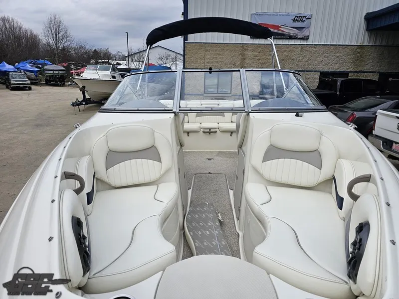 Slide: The Image of 2013 Stingray 225 LR boat with white interior, docked outdoors. - 16