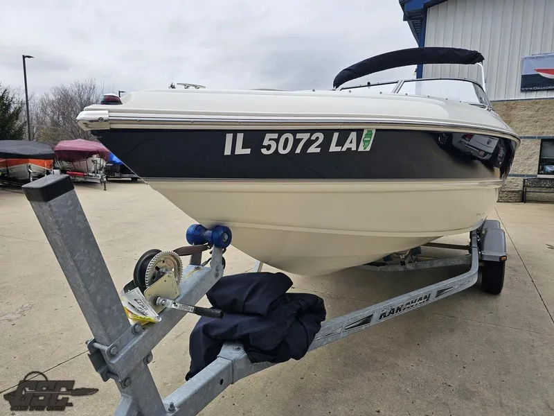 Slide: The Image of 2013 Stingray 225 LR boat on trailer, parked outside a building. - 17