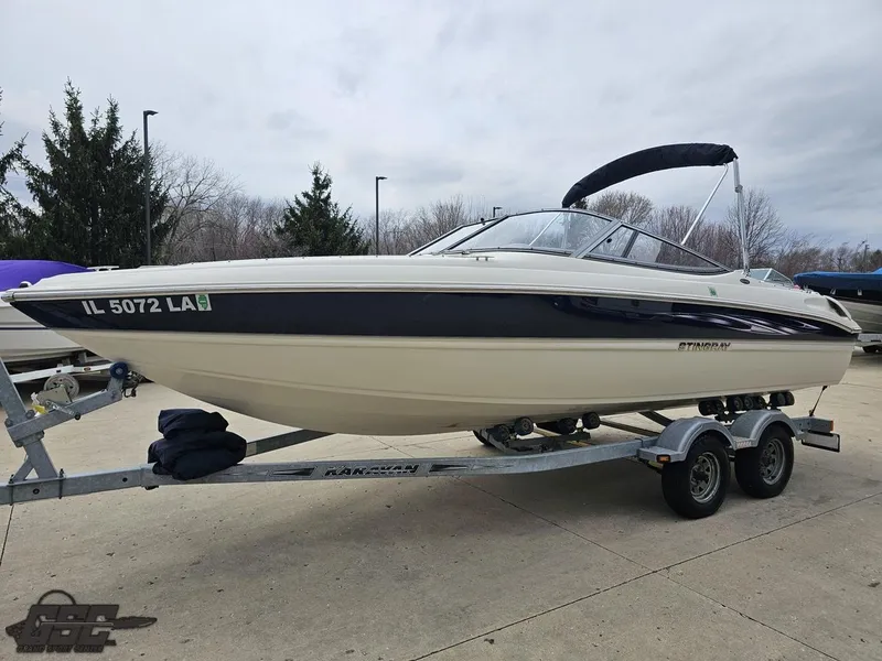 Slide: The Image of 2013 Stingray 225 LR boat on trailer, parked outdoors. - 19