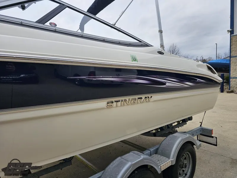 Slide: The Image of 2013 Stingray 225 LR boat on trailer, side view, showcasing sleek design. - 21