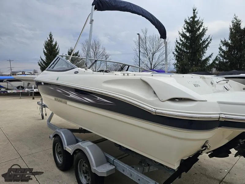 Slide: The Image of 2013 Stingray 225 LR boat on trailer, parked outdoors, overcast sky. - 27