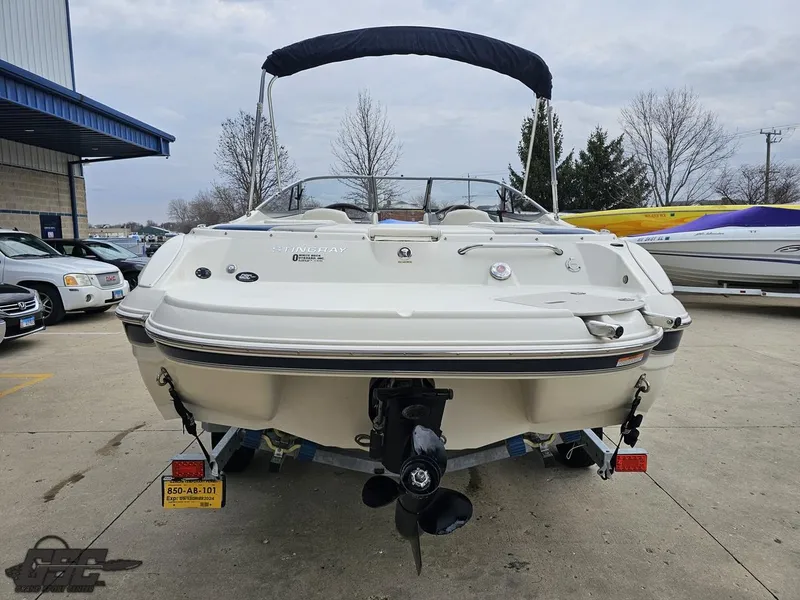 Slide: The Image of 2013 Stingray 225 LR boat with canopy, parked outdoors on a trailer. - 29