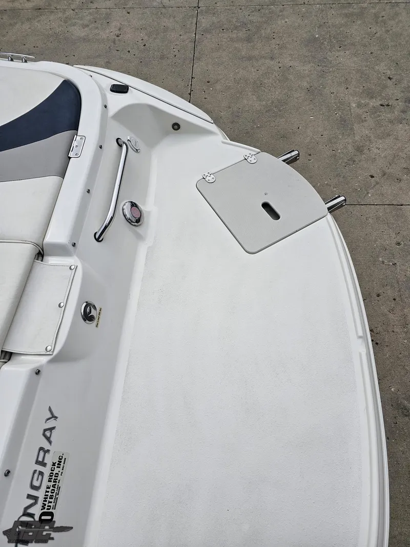 Slide: The Image of 2013 Stingray 225 LR boat deck, white finish, sleek design, docked on concrete surface. - 36